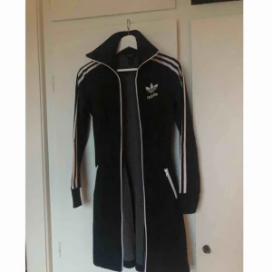  - Lång adidaströja, figursydd med hög krage och fickor. Svart. Skitsnygg! Frakt tillkommer