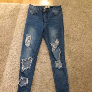  - Jeans med slitningar. Frakt tillkommer