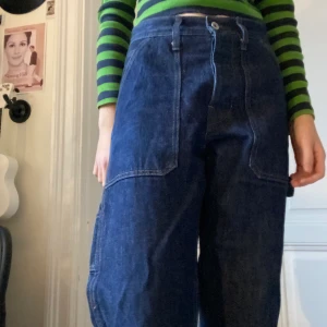 Snickarbyxor:) - Ett par snygga snickarbyxor liknande jeans jag har köpt här på plick men inte har fått så mycket användning av tyvärr. De var väldigt stora så därför är de insydda där bak nu. Så de passar nog storlek 26-27 nu kanske. Den saknar även en ögla för bältet eftersom byxorna är insydda. Jag skulle även säga att de är lite baggy.  Jag kan mötas upp eller så tillkommer frakt. Den ligger nog runt 44-66kr💕