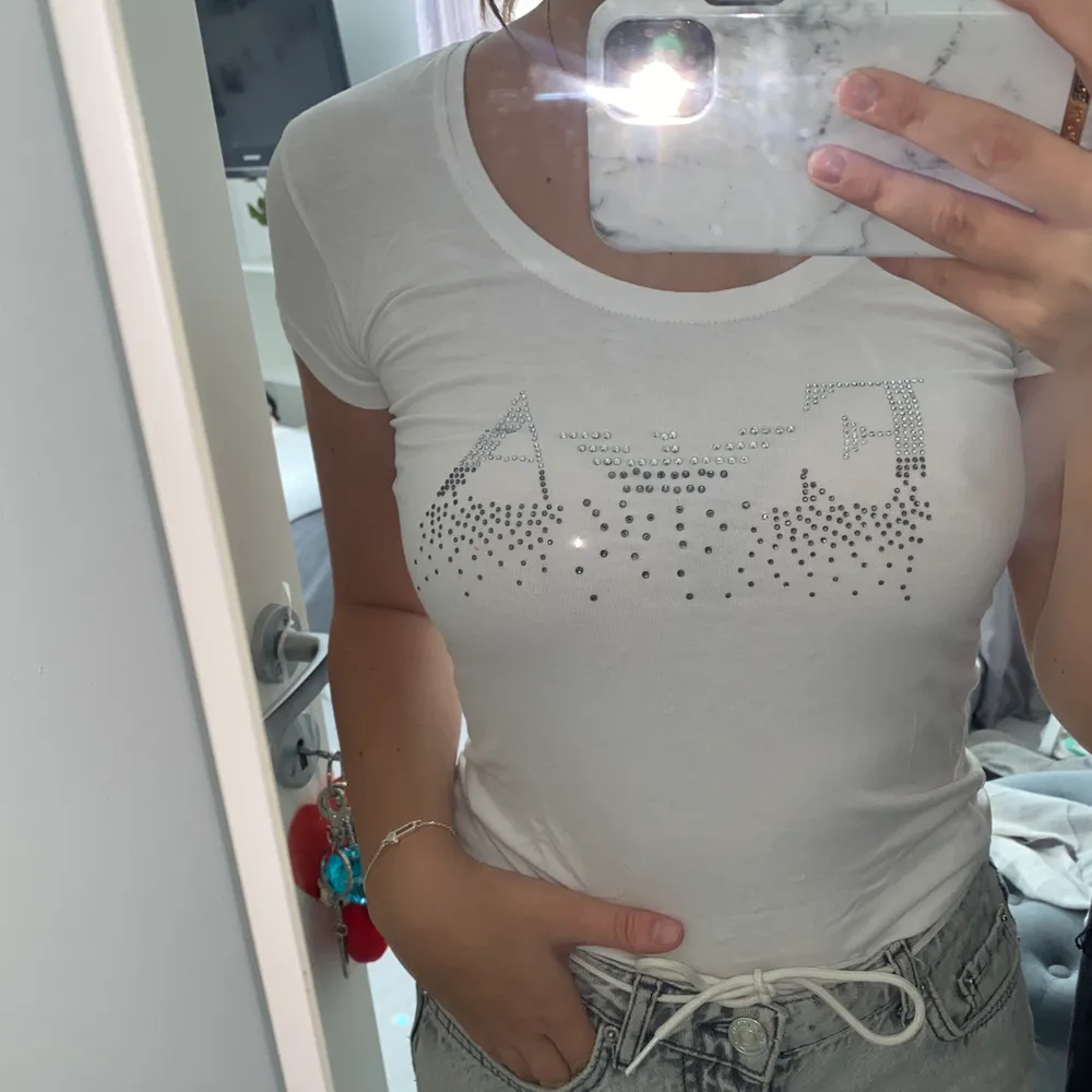 En äkta vit Emporio Armani t-shirt, nästan helt oanvänd och har tryck på bröstet. Den är i storlek XS/S. T-shirts.