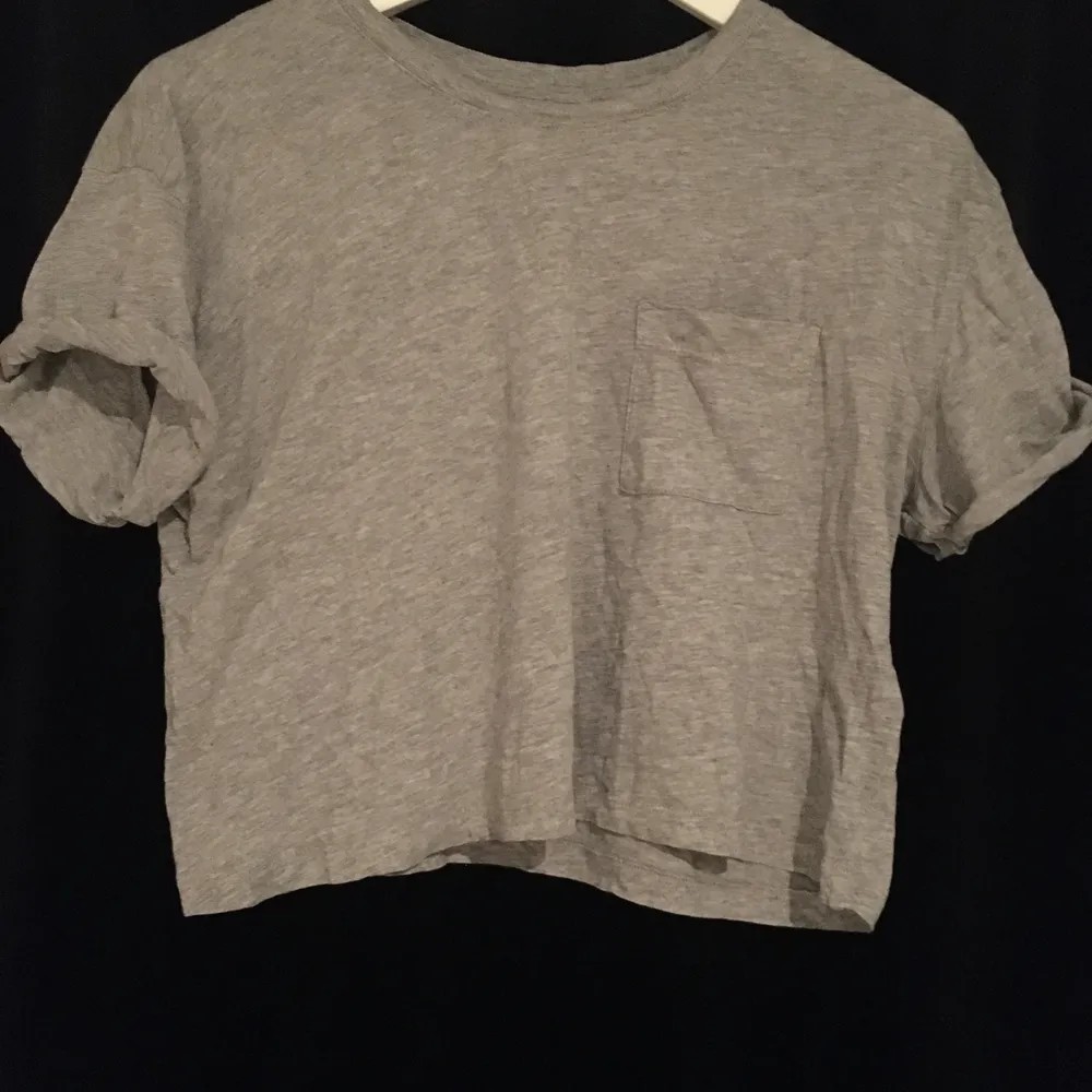 En grå t-shirt med en ficka på bröstet, väldigt stilren och fungerar till allt, använd få gånger (priset kan alltid diskuteras). T-shirts.