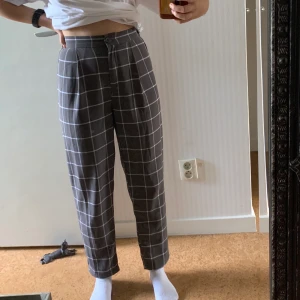 Rutiga byxor - Rutiga byxor i en lila/grå färg✨ stretchig midja. Knapp och dragkedja där fram. Tunnt och svalt material. Sparsamt använda💞 Jag är cirka 158cm lång. Storlek 34. Frakt ingår i priset. Skriv om du har några frågor🌸