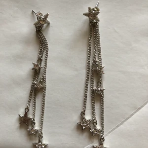 Långa stjärnörhängen - Långa (ca 5 cm) örhängen med stjärnor. Anv en gång, som nya! Köpta på Kappahl