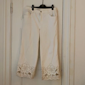 Anthropologie white wide leg jeans - LOVE these pants. Selling them because they no longer fit. Really beautiful gold floral detail on the bottom. Free delivery in Stockholm. Payment by Swish.