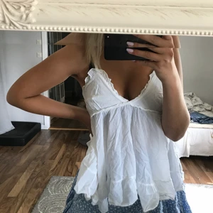 Somrigt linne - Ett somrigt och V-ringat linne med volang längst ned och markeringar vid brösten. Linnet är i fint skick. Står ingen storlek på linnet men passar bra på mig som är S/M