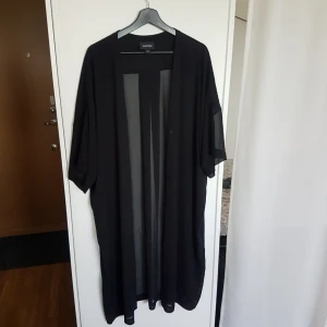  - Svart genomskinlig kimono i xs/s men passar de flesta storlekar, längd ca. 113cm. Knappt använd och i bra skick. 