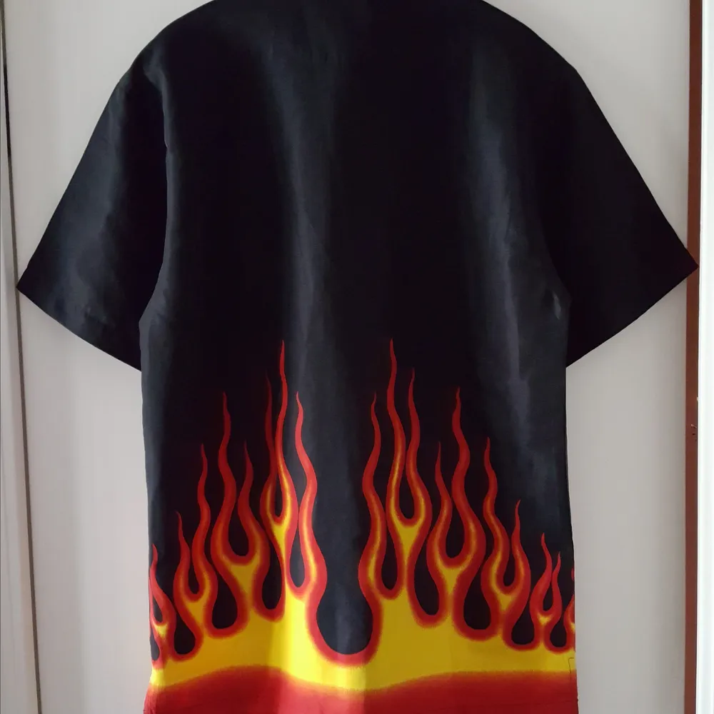 Vintage svart skjorta med eldflammor på. Storlek S men är stor i storleken och mer som ca en storlek L. Kan skickas om köparen står för frakten som blir 36kr.. Övrigt.