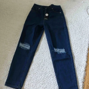  - Helt nya högmidjade momjeans från Boohoo. Aldrig använda och prislappen kvar. Skriv gärna vid intresse :) samma storlek som hon på bilden har (storlek 38)