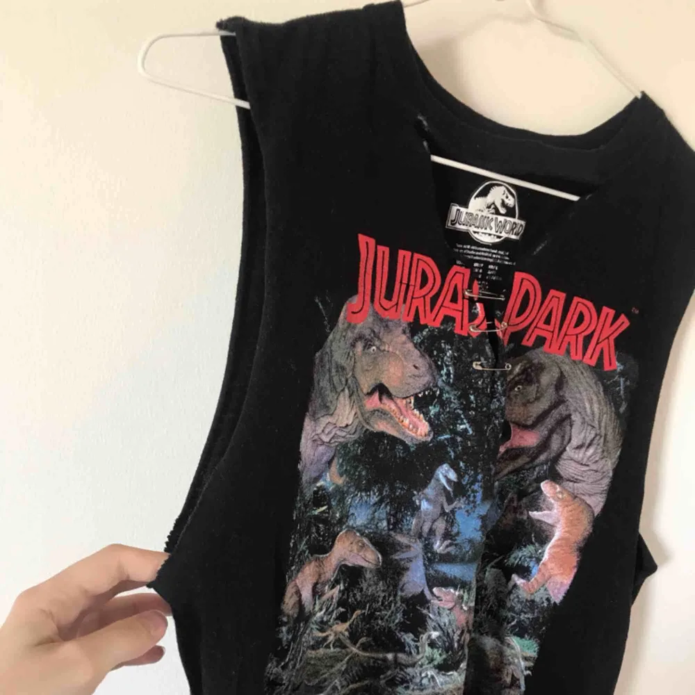 🦖 Jurassic World tank top från forever 21. Har en utklippt v neck med en ”chocker” som lätt går att klippa bort om man skulle vilja. Den är ganska lång men går att klippa. Säljer för 40 kronor + frakt! . T-shirts.