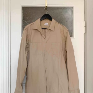  - Snygg skjorta med snygga sömmar och neutrala knappar. Bra skick. Stl L  Har Swish. Kan skickas. Rökfritt & djurfritt hem.