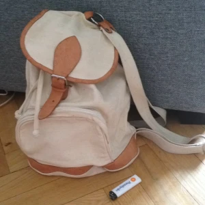  - Vit tygryggsäck med detaljer i äkta skinn. Vintage. Kan mötas upp i sthlm eller skicka. Köparen betalar frakt. Swish, överföring eller cash går bra. 