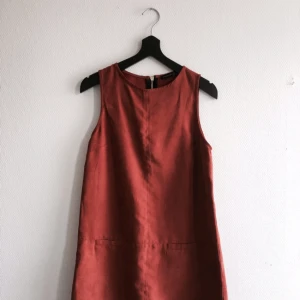  - Roströd klänning i mockaimitation. Guldig dragkedja i bak. Köpt via plick men passade mig tyvärr inte. Perfekt till våren!

Fraktar eller möts upp i Stockholm/norrort.