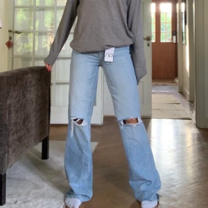 Zara jeans långa - Säljer mina zara jeans med hål! De är använda ett par gånger och avklippta liite där nere så de precis nuddar marken på mig som är 1.65 (se bild 2) inga skador, de har blivit liite uttöjda i midjan och hålen har blivit lite större! Skriv för mer bildar privat!