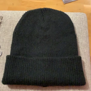 Svart stickad mössa - Så fin svart stickad mössa. Aldrig använd men eftersom jag aldrig använder mössor säljer jag den. Frakt ingår ej i priset! Säljs även i grått.