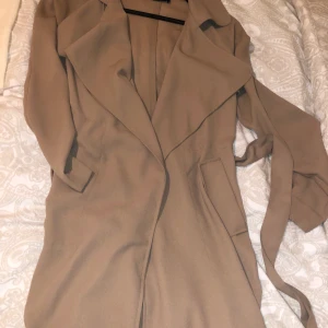 Fin tunnare långkappa  - Fin beige tunn långkappa med band till  