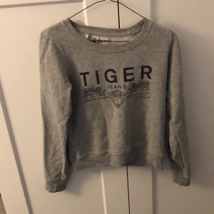 Tiger Tröja - Grå collagetröja från Tiger of Sweden, i använt men väldigt fint skick. Storlek xs, 150kr inklusive frakt.