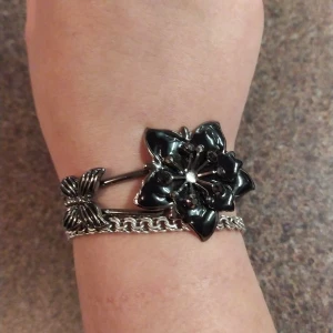 Snyggt armband med svart blomma och fjäril - Med gnistrande stenar, öppningsbart. Supersnyggt till jul och nyårfesten!