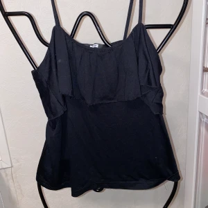 Volang topp Bikbok - Bra skick. I storlek SMALL. Fin topp med volang över bröstet. Från bikbok. Mörkare svart i verkligheten. Kan skickas mot fraktkostnad. Fler bilder kan ordnas vid intresse.  
