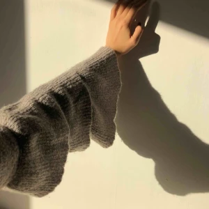  - Grå-beige stickad tröja från NAKD med volangärmar. I bra skick!