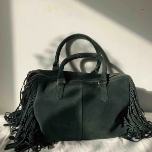 Väska i äkta mocka - Knappt använd mockaväska från TOPSHOP. Supermjuk äkta mocka, inga spår av användning samt detaljer i guld. Nypris ca 799kr.