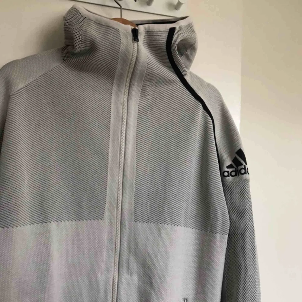 Träningsjacka/hoodie från adidas helt oanvänd i polyester med huva. Frakt tillkommer. Hoodies.