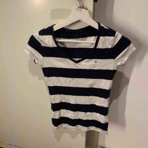  - En vit och blårandig Tommy hilfiger T-shirt. Använd ett fåtal gånger men i bra skick. Köpt för några årsedan. Köparen står för frakt