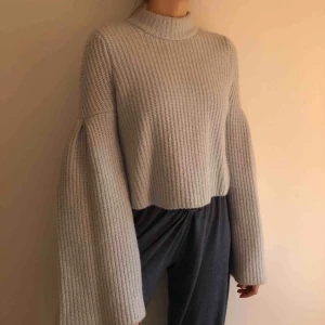  - Fin tjockt stickad tröja i ljusblått med stora vida ärmar. Något kortare, boxig modell.