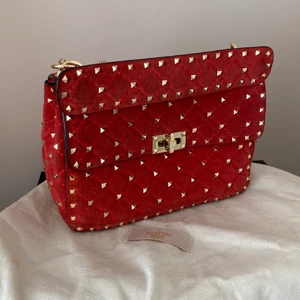 Valentino rockstud väska - ‼️Kvitto finns‼️Röd valentino väska med guldiga nitar, i mellanstorleken. Den är välanvänd, men i fint skick, mockan syns, lite blekt, på första och sista bilden och fler bilder kan ordnas!!!