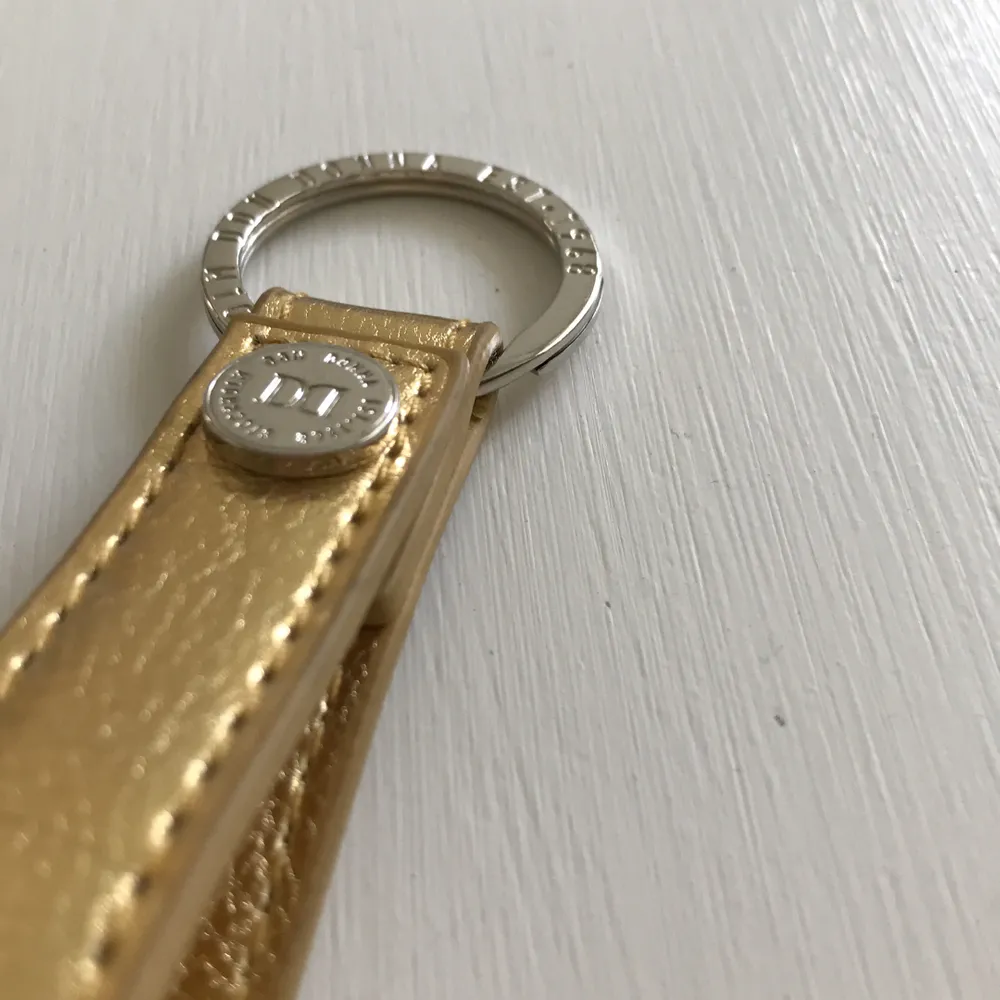 Guld nyckelring från märket don donna med silver detalj. Helt ny. 30kr ink frakt. . Accessoarer.