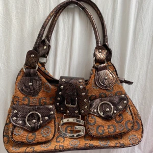 Guess väska  - Säljer en jättefin guessväska köpt vintage, därav har jag inget äktahetsbevis eller likande. Superfint skick!        🚨MÅNGA INTRESSERADE - budgivning pågår, högsta bud atm är 400kr. Avslutas på söndag, buda helst i kommentarerna. 🚨