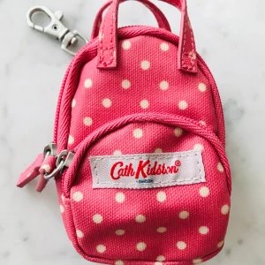 Cath kidston väska - Otroligt söt miniryggsäck från märket cath kidston.💖Köpt i London men har tyvärr aldrig kommit till användning.. Säljer för 60kr+30kr frakt. Innehåller två små fack med dragkedjor och en liten karbinhake. 