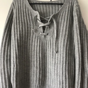 Grå tröja. Storlek M. - Grå tröja med snörning. Tröjan är i storlek M men kommer passa S samt L. Köparen står för frakt. 🌸