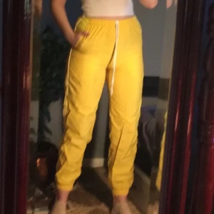Gula byxor - Byxor i ett ”windbreaker” materiel. Köpta secondhand och är använda endast en gång av mig, skulle säga nyskick! Skriv för  mer info/bilder. Köpare står för frakt 📦 
