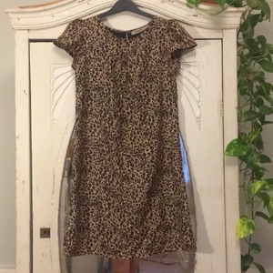 Leopardmönstrad klänning - En leopard mönstrad klänning. Nästan aldrig använd. Går till knäna på mig som är ca 155cm. Står M men är mer som S. Skriv om fler bilder behövs! 