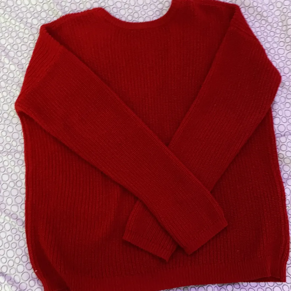 En röd stickad tröja med urringning bak ifrån Na-kd. Helt fel fri! 💞💞. Stickat.