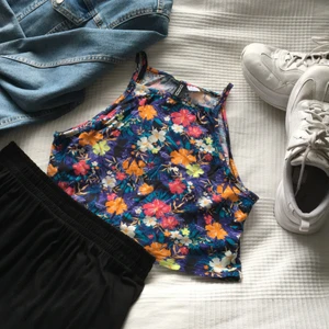 Linne - Blommigt croppad linne med hög hals och tunna band. Det är knappt använt och i nyskick. Storleken är m och det sitter perfekt! 