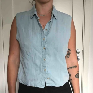  - En ärmlös jeansskjorta i ljusblått från Topshop petite i storlek 36.✨köparen står för frakt 