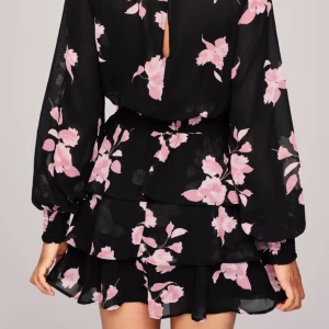  - 100 kr med frakt ! Använd 1 gång, den är som ny Stl 38 Nypris 299 Vävd klänning i chiffong med volangkjol och smock i midjan. Klänningen har lång ärm och stängs med knapp i nacken. Normal passform. Slutar en bit ner på låret.  