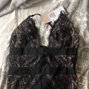  - Säljer denna snygga spetsbody från H&M som har korsade band i ryggen. Super snygg men har tyvärr inte fått användning av den. Lapparna är kvar och den är bara testad med trosskyddet på 