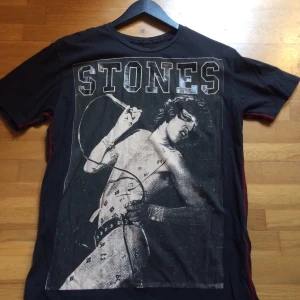 Mick Jagger tshirt - Oanvänd tshirt med Mick Jagger i snygg faded svart färg och röda detaljer på sidorna. Storlek L. Ganska dyr i inköp, därav mitt pris. Priset är inkl vanlig frakt 🌸 OBS: Har ej möjlighet att visa hur den ser ut på.