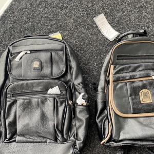 Svarta ryggväskor - Två ryggsäckar helt oanvända.  Båda har väldigt många fickor både på framsidan och baksidan samt två fickor inåt i (en mycket mindre inåt i den andra).  Säljer båda för 400kr eller varje individuellt för 250kr.