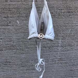 Michael Kors bikiniöverdel  - Köpt här på Plick av någon annan men var alldeles för stor för mig. Det är en M men jag skulle säga mer en L. I bra skick. Knyts runt halsen och ryggen. Frakt är inkluderat i priset!