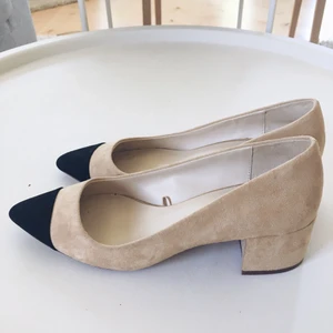 Beiga och svarta pumps i strl 35 - Sparsamt använda och i superskick (se klacken på bild 3). Sköna att gå i och perfekta på sommaren. Skickas mot frakt. 