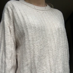 Stickad tröja - En fin stickad med tjockare kant runt halsen. Mönster över hela och färgen är ljusbeige med lite rosa i⭐️ skulle säga att den är stor i storleken. Sticks inte✨🌸