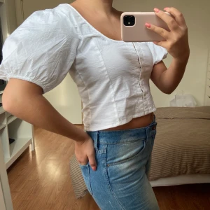 Vit blus, Nelly strl. 36 - Jättefin vit blus med puffärmar från Nelly. Blusen knäpps framtill med hakar och hyskor. Inköpt i våras. Aldrig använd p.g.a för stor för mig. Tyvärr ingen prislapp kvar. Blusen är stor i storleken och i stretchigt material. Snarare strl 38, än 36.