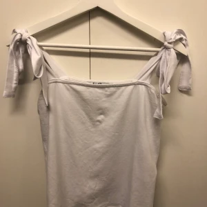 Vitt linne - vitt linne från NAKD, fin detalj med knytning på axlarna, endast använd en eller två gånger 