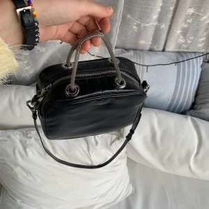 Hand väska - Söt handväska, inte förstår men ändå väldigt rymlig pga att den är kvadratisk! Cool detalj med dem små gråa ”kedje” handtagen. Använd väldigt få tal gånger pga att ja inte fått användning av den! Ja köpte den från zara!