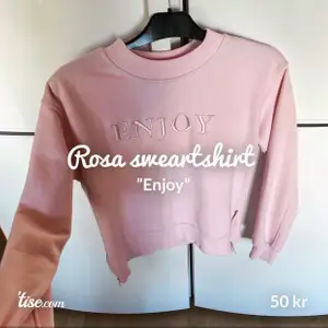 En superfin rosa sweatshirt med texten ”enjoy” i strl xs-s. Den har dragkedjor längst ner på sidorna, se bild 2. Frakt tillkommer, kan gå ner i pris vid snabb affär 🦋