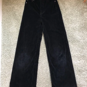 Svarta Manchesterbyxor Weekday  - Svarta Manchester byxor från Weekday i bra skick i storlek 34. Byxorna är högmidjade och har vida ben. Ny inköpta för 500kr. 63kr tillkommer med frakt 