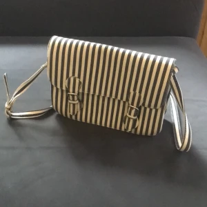Axelremsväska  - Randig axelremsväska. Sparsamt använd. Från zara (?). Höjd 20 cm. Bredd 28 cm. Bottendjup 7 cm. Mörkblå och vit